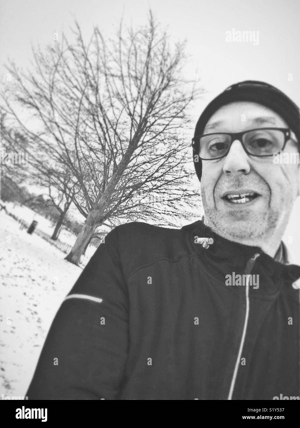 Im mittleren Alter Mann im Schnee läuft Stockfoto