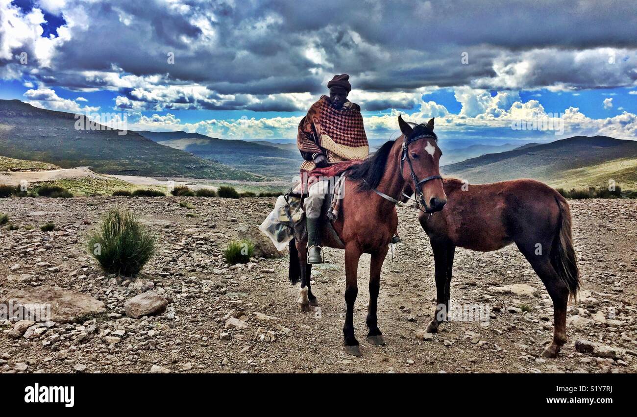 Lesotho Hirt zu Pferd in die trostlose Afrikanischen Hochland Beweidung Plains Stockfoto