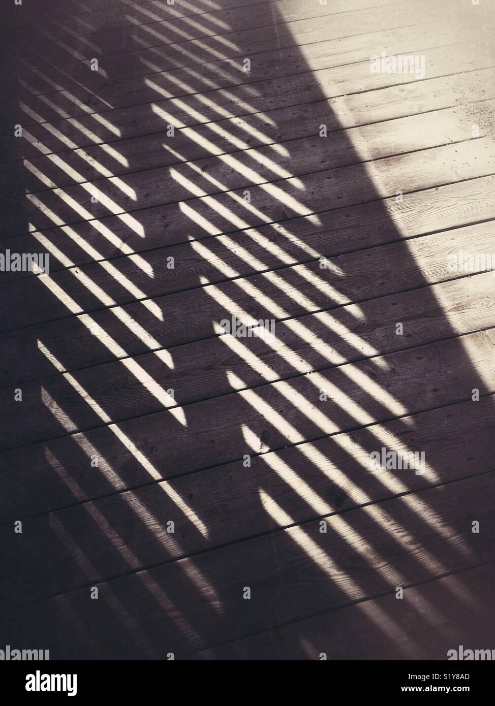 Zaun Schatten fallen auf der Promenade. - Smartphone-aufgenommenes Stockfoto