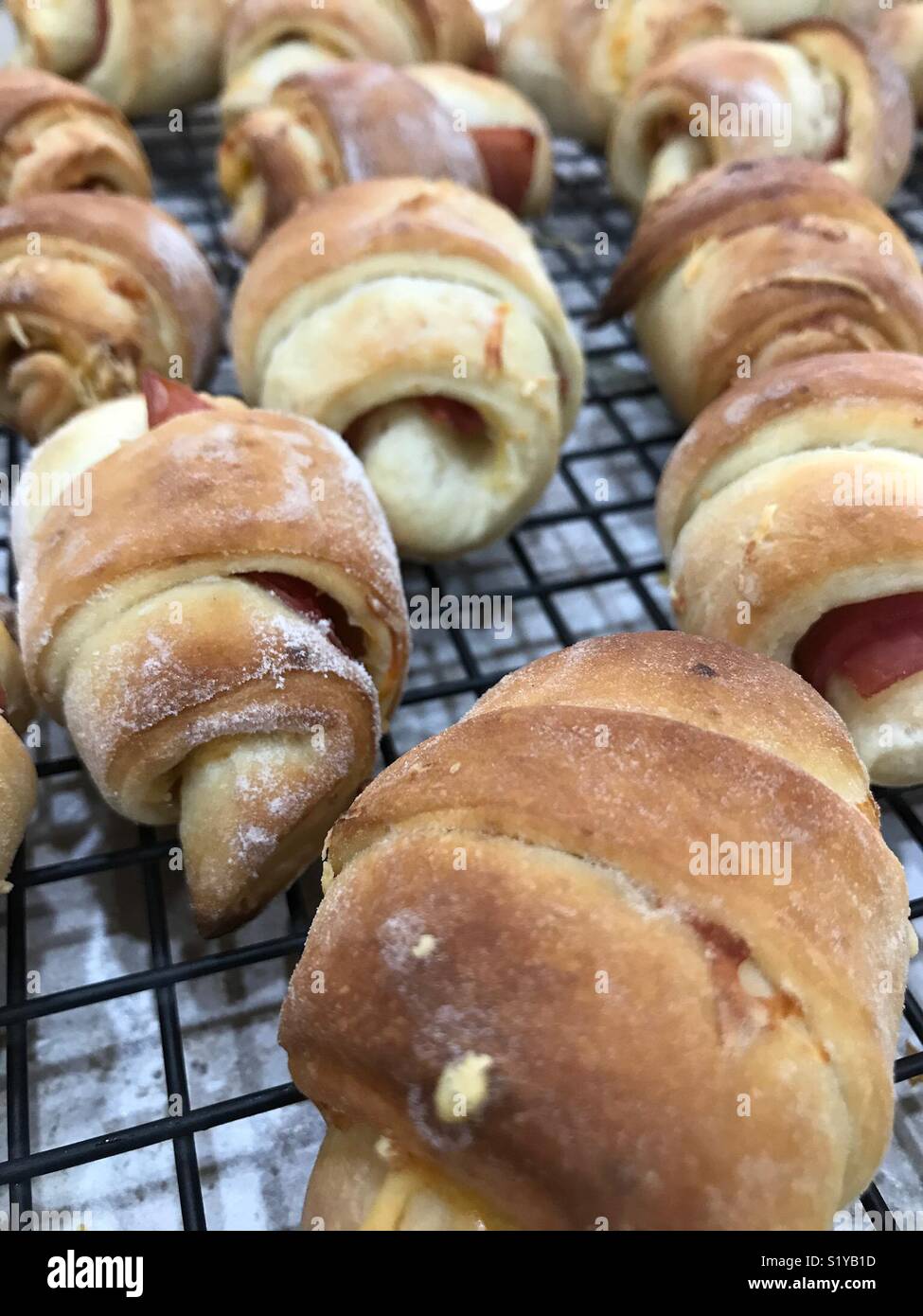 Schinken und Käse roll-ups sitzen Kühlung auf Bäcker Zahnstange. - Smartphone-aufgenommenes Stockfoto