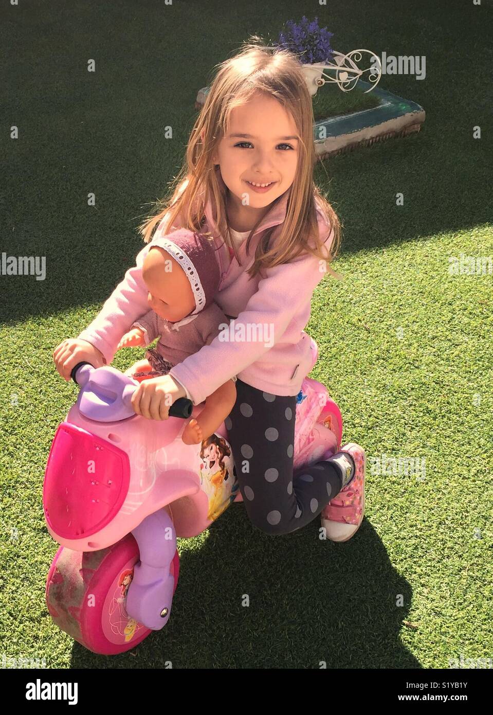 Kind beim Spielen im Garten, niña en El Jardín, jugando con sus juguetes, mit ihrem Spielzeug, glücklich, Feliz Stockfoto