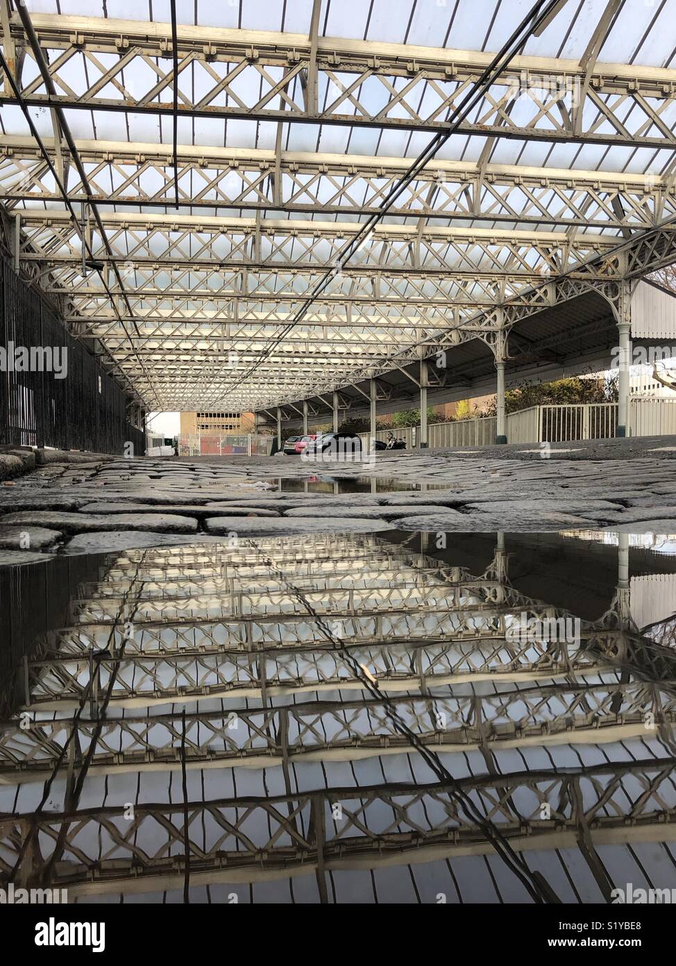 Reflexion aus Stahl und Glas dach in einer Pfütze Stockfotografie - Alamy