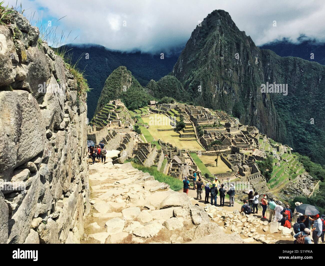 Touristen gesäumt, grandiose Aussicht auf Machu Picchu zu bewundern. Stockfoto