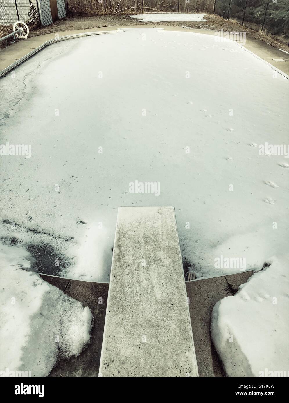 Outdoor inground Pool im Schnee und Animal Prints abgedeckt - Smartphone-aufgenommenes Stockfoto