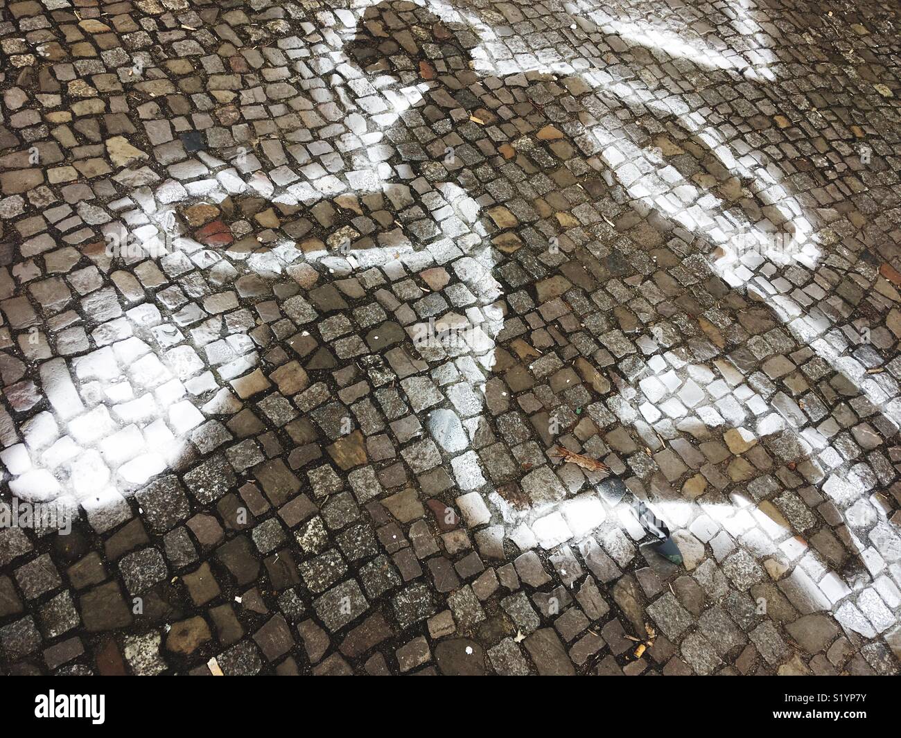 Ein Mann mit Hut auf gepflasterten Gehweg gesprüht Stockfoto