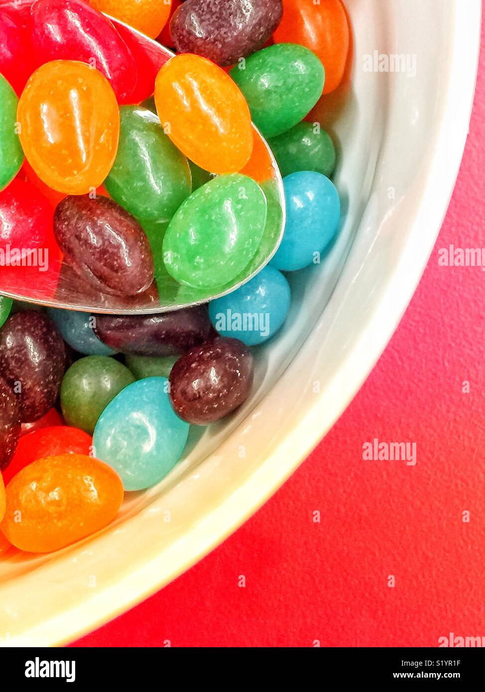 Runde Schale mit Jelly Beans auf rote Tabelle ausgefüllt Stockfoto