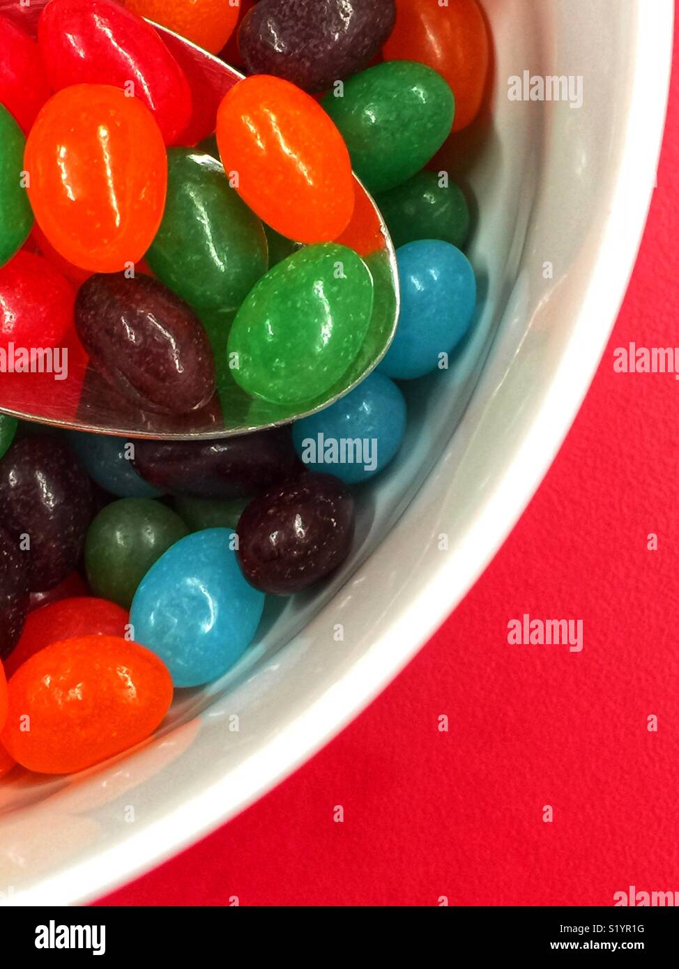 Nahaufnahme der runde Schüssel mit Jelly Beans auf rote Tabelle ausgefüllt Stockfoto