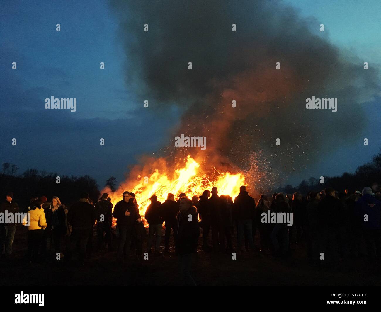 Ein großes Lagerfeuer in der Dämmerung - Smartphone-aufgenommenes Stockfoto