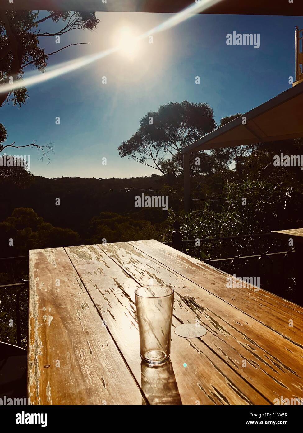 Leere Bier Glas auf einem Holztisch mit Flare von der Sonne Stockfoto