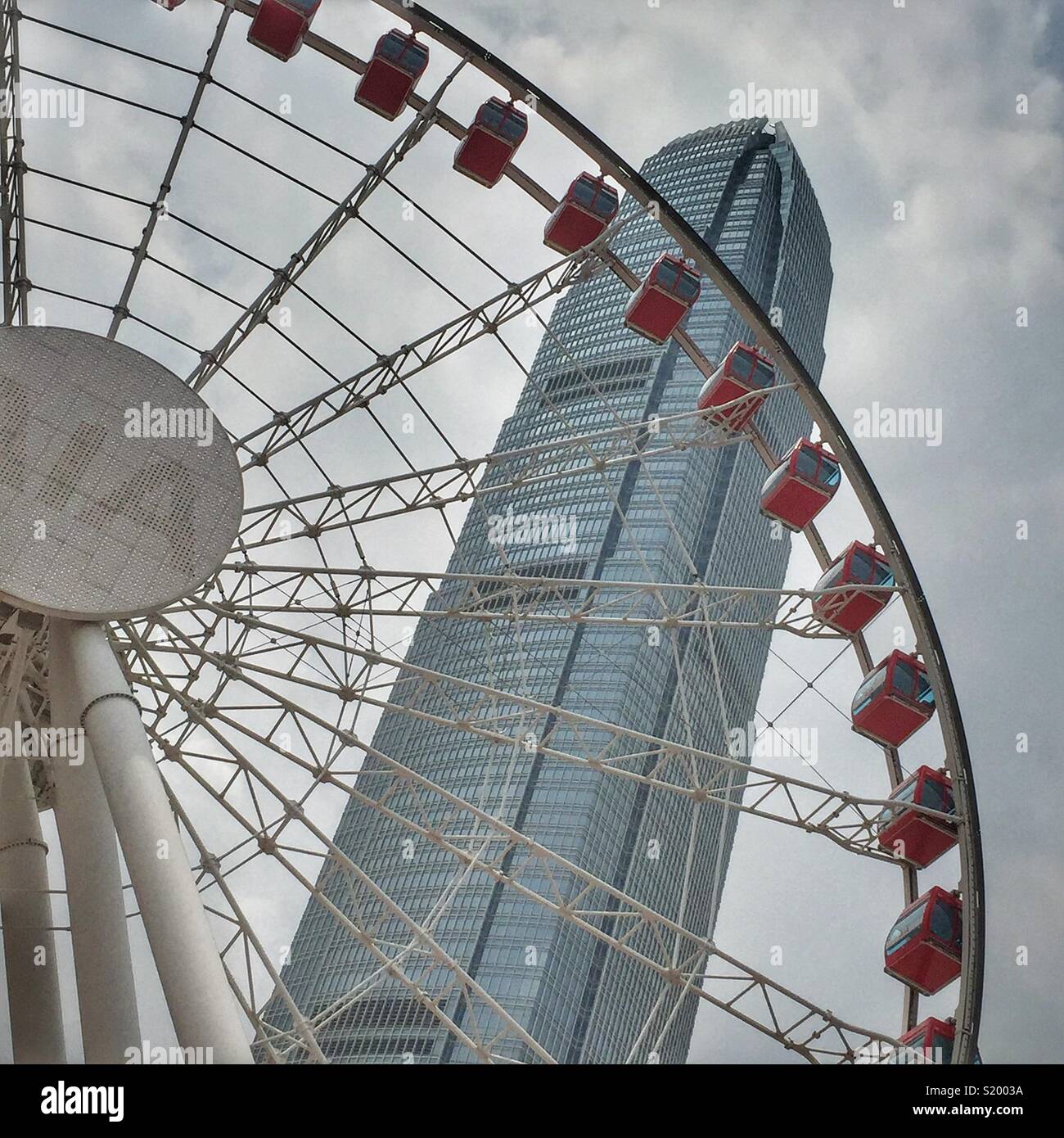 Das Riesenrad für Touristen an der Central Waterfront in der Nähe der Landungsstege 9 und 10 mit dem höchsten Gebäude von Hong Kong Island, 2 ifc Stockfoto
