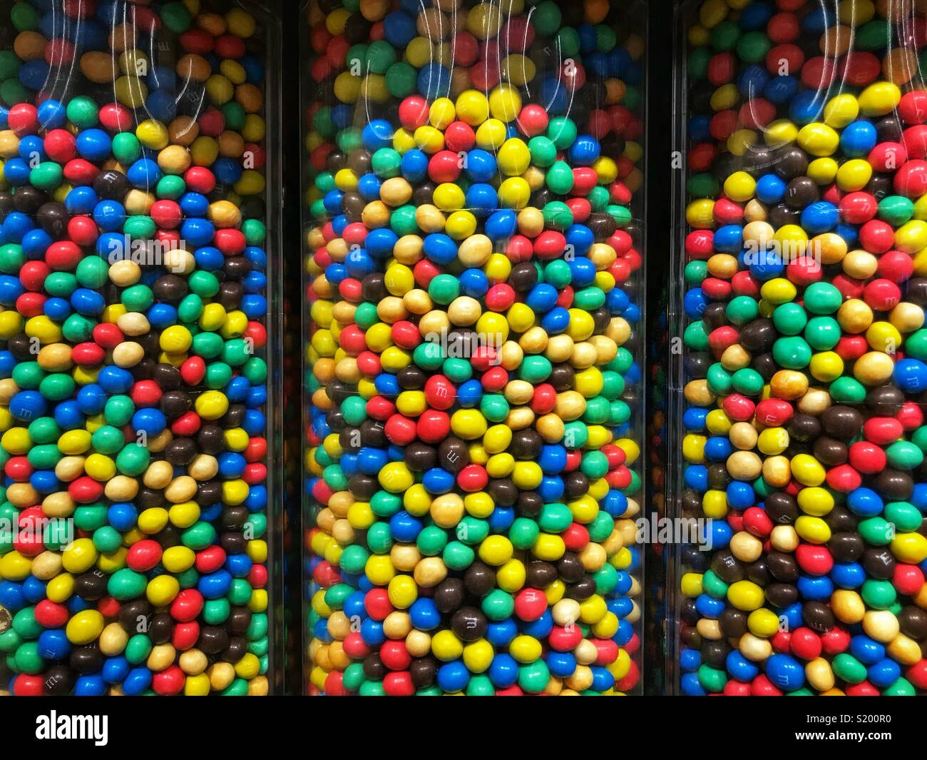 M&Ms candy in Röhrchen in einem Fachgeschäft. - Smartphone-aufgenommenes Stockfoto
