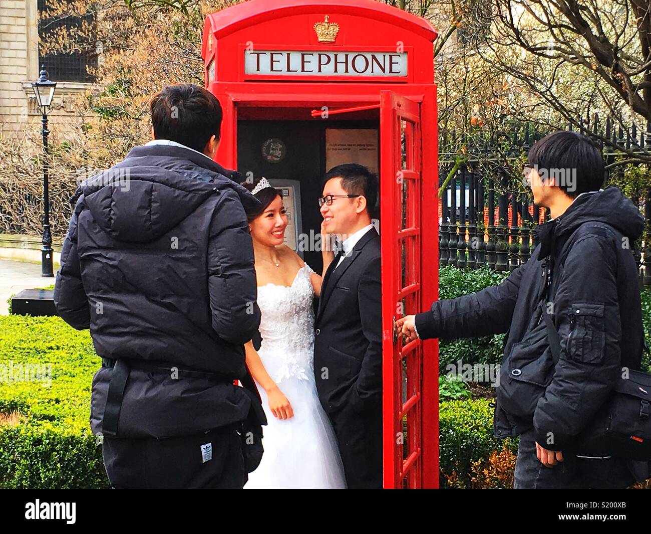 Ein paar posieren für Fotos Hochzeit in einem berühmten britischen roten Telefonzelle außerhalb von St. Paul's Cathedral in London, England Stockfoto