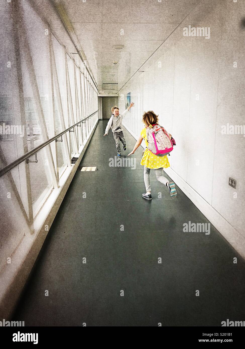 Zwei Kinder so tun, als Flugzeuge in einem Flughafen Gangway zu sein. Stockfoto