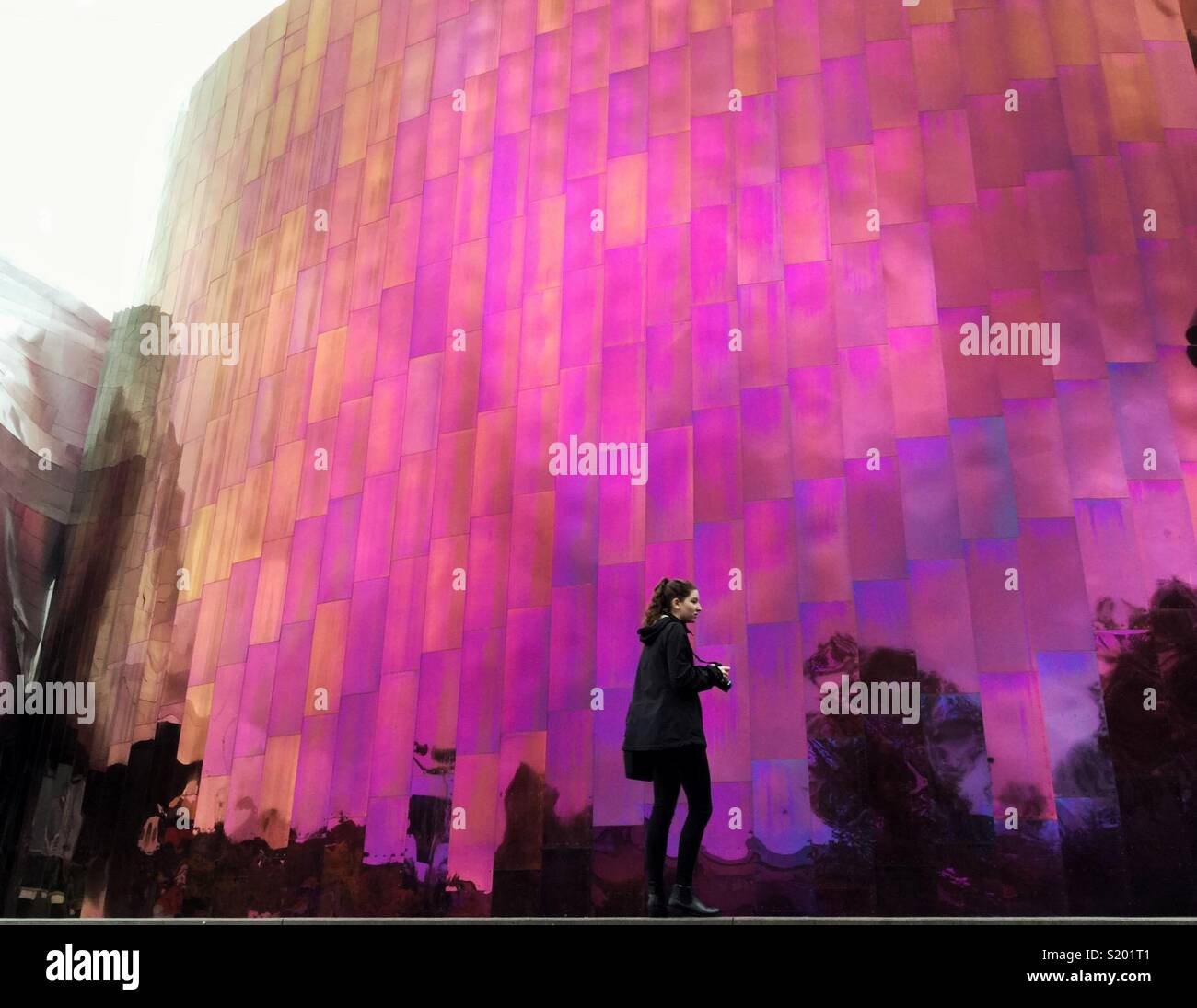 Junge Frau an der Purple Rain Wand von MoPop Museum von Architekt Frank Gehry in Seattle. Stockfoto