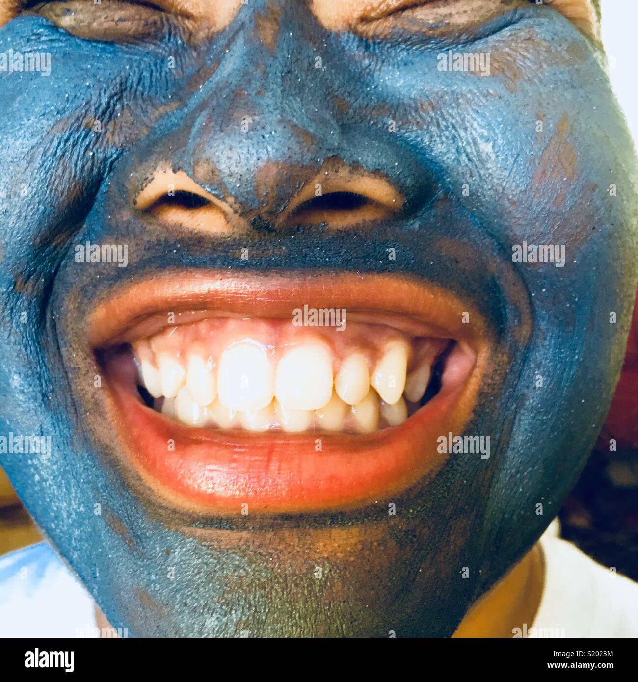 Mädchen mit blauen Schlammpackung Gesichtsmaske Stockfoto