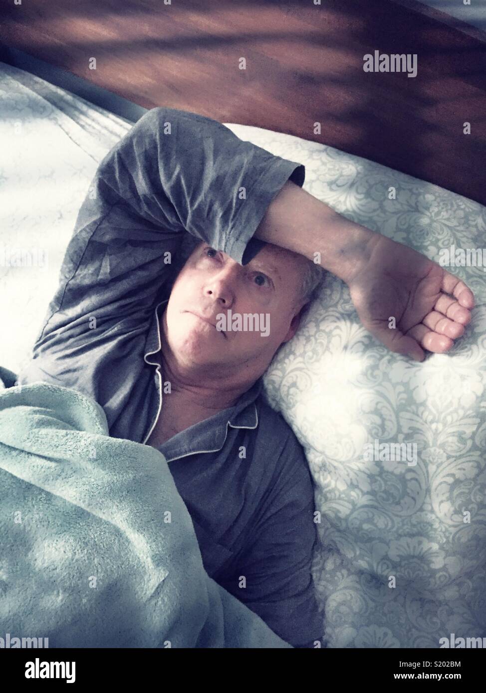 Senior kaukasischen Mann beunruhigend und nicht schlafen, USA - Smartphone-aufgenommenes Stockfoto