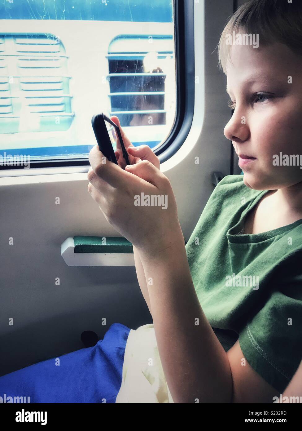 Ein Junge Typen auf seinem Telefon, während auf einem Zug in Delhi, Indien. Stockfoto