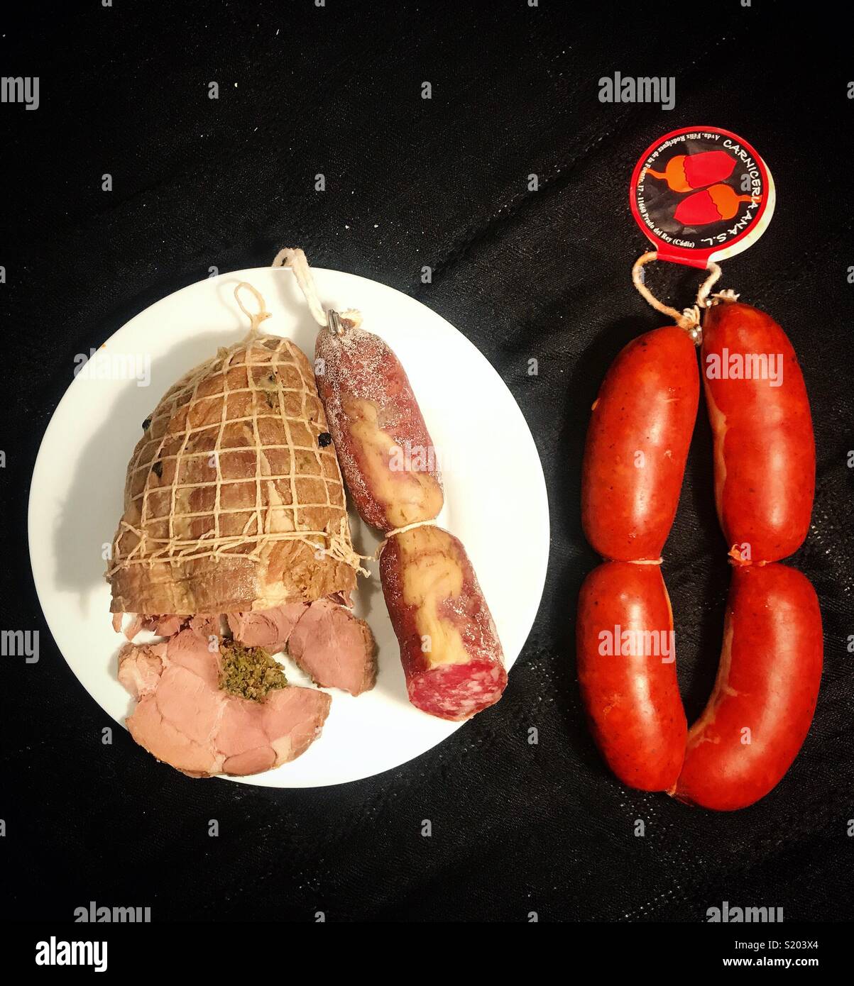 Hackbraten, Salami und Wurst von iberischen Schweinen aus carniceria Ana in Prado del Rey, Sierra de Cadiz, Andalusien, Spanien - Smartphone-aufgenommenes Stockfoto