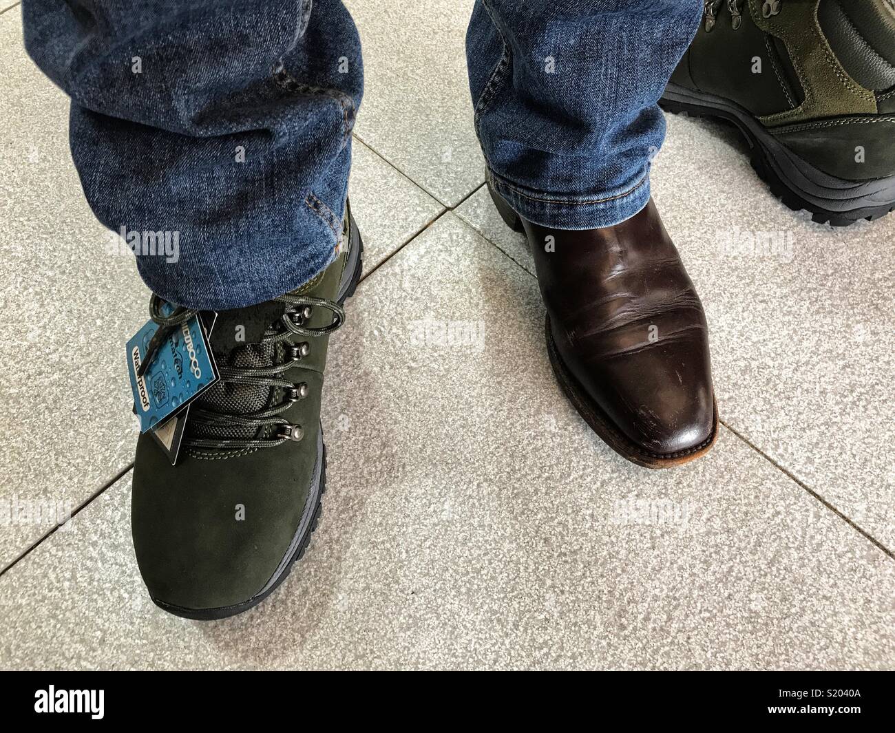 Versuchen, auf die Wanderschuhe in einem spanischen Schuhladen - Smartphone-aufgenommenes Stockfoto