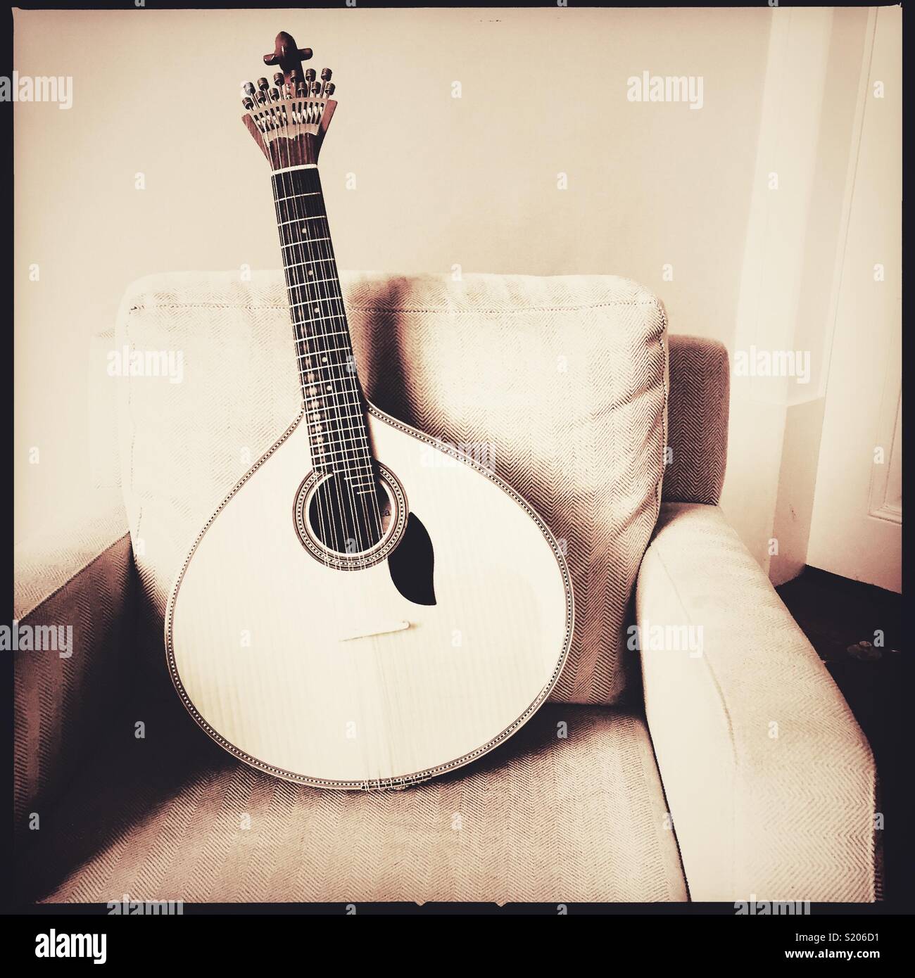 Portugiesische Gitarre lehnte sich auf Stuhl Stockfoto