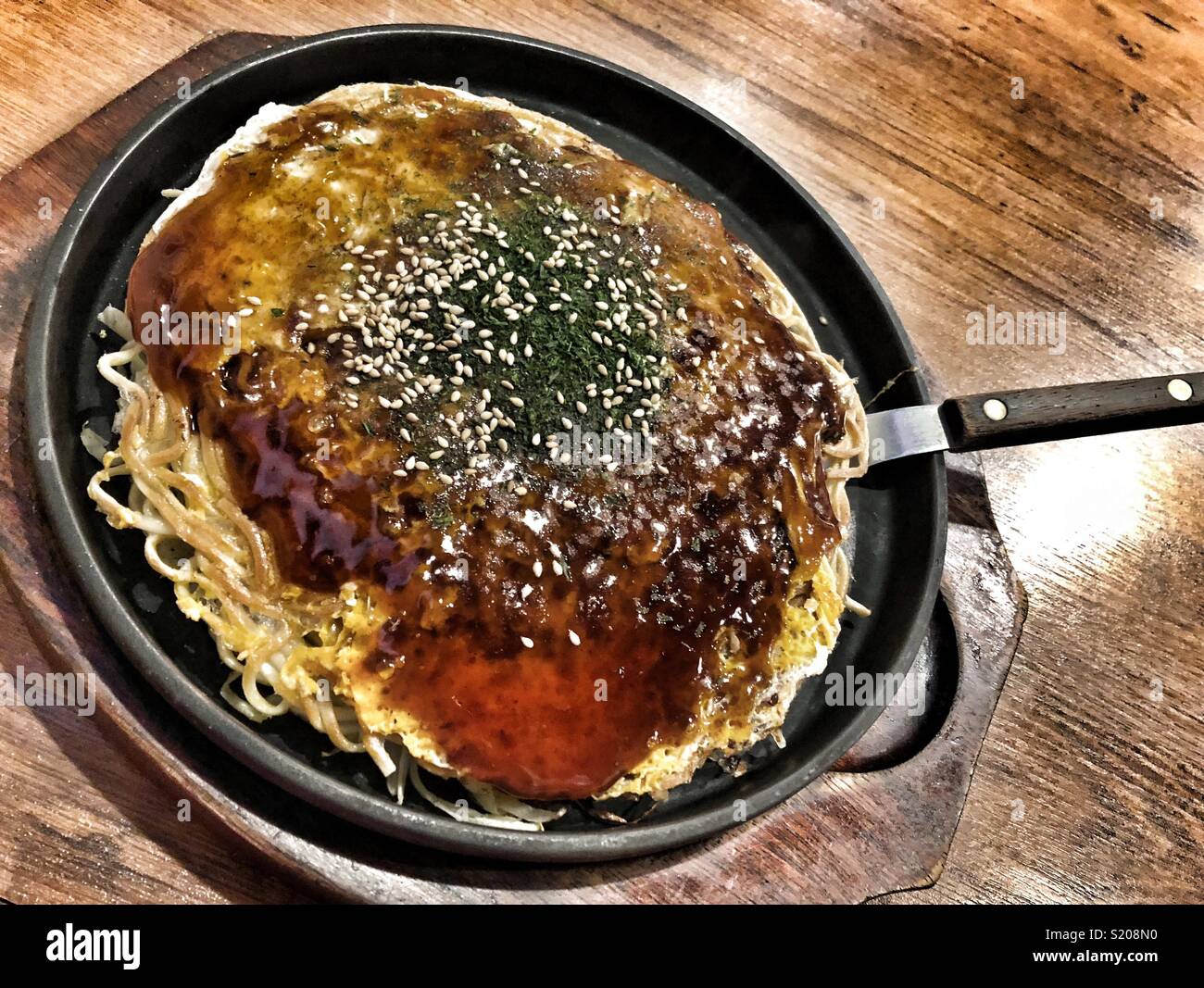 Okinomiyaki, eine typische japanische Delikatesse. - Smartphone-aufgenommenes Stockfoto