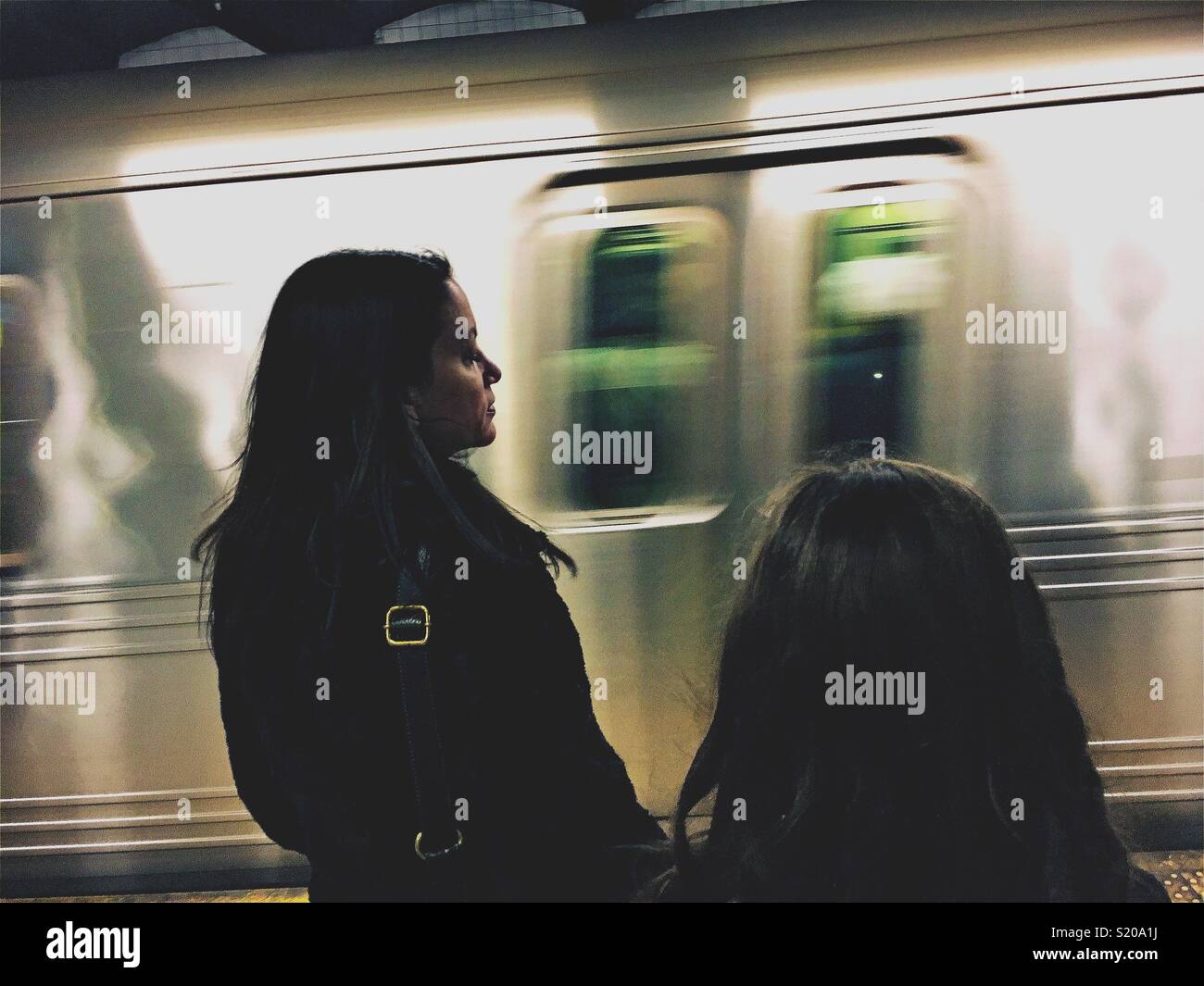 Frau und Mädchen warten auf der U-Bahn Stockfoto