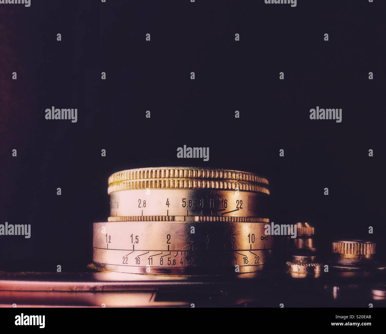 Ansicht von oben Nahaufnahme einer alten Kamera Objektiv mit den Werten von Aperture graviert, auf schwarzen Hintergrund mit Kopie Raum isoliert. - Smartphone-aufgenommenes Stockfoto