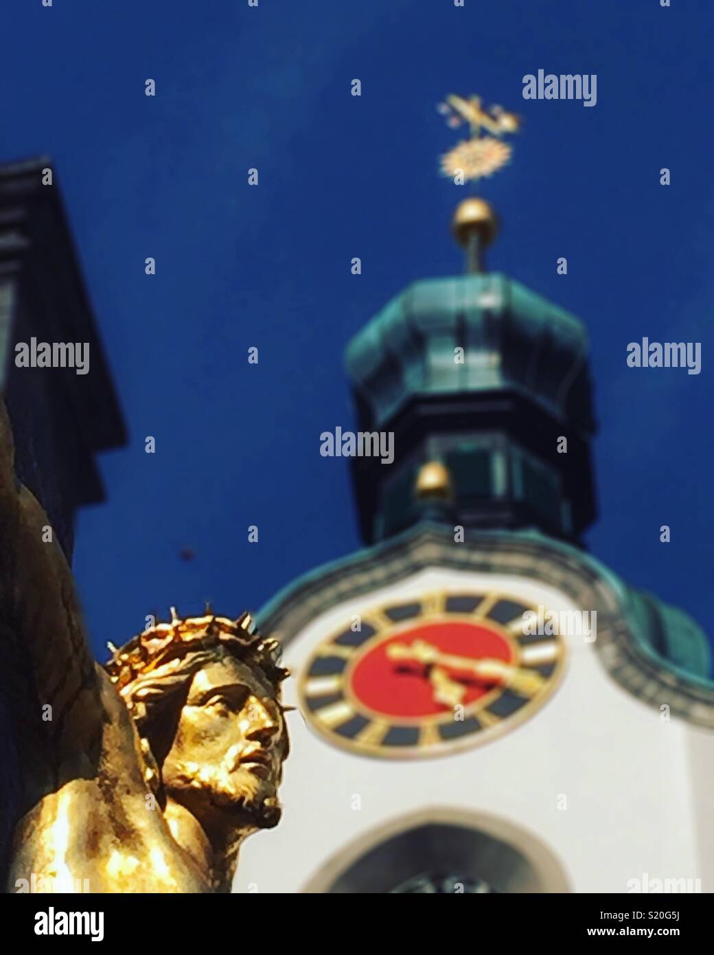 Golden Jesus und Kirchturm, Schweiz - Smartphone-aufgenommenes Stockfoto