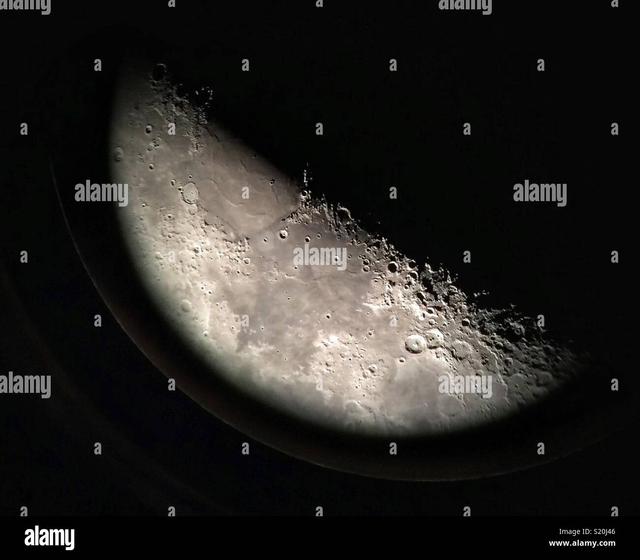 Der Mond. Foto nähert sich das Telefon an das Auge eines Teleskops (70x). - Smartphone-aufgenommenes Stockfoto