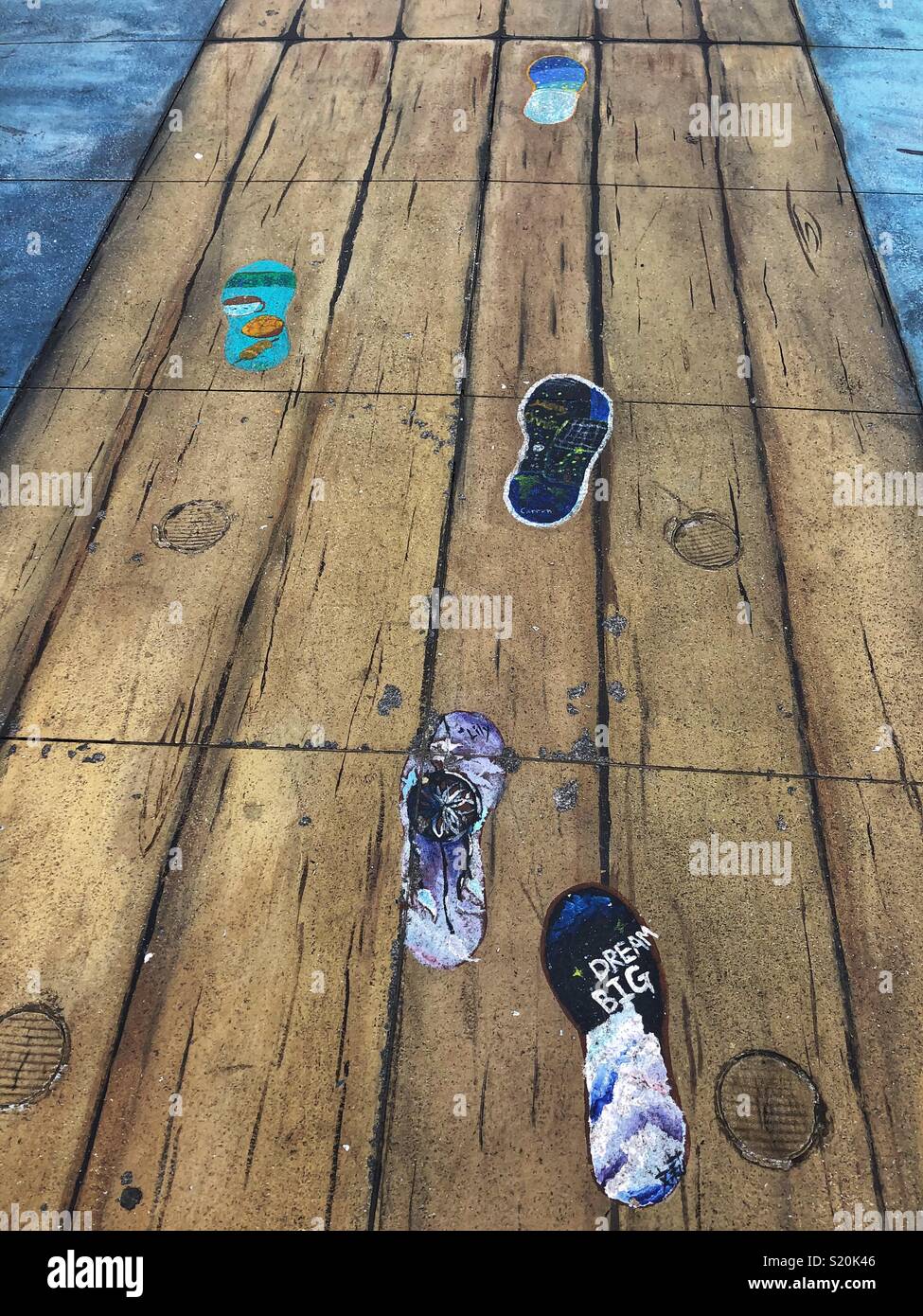 Hong Kong Straße Kunst - gemalte Gehweg mit der Darstellung eines hölzernen Pier mit Footprints. Stockfoto