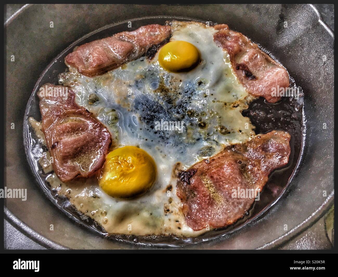 Eier und Speck braten Ich bin ein Cast Iron Skillet Pan. Stockfoto