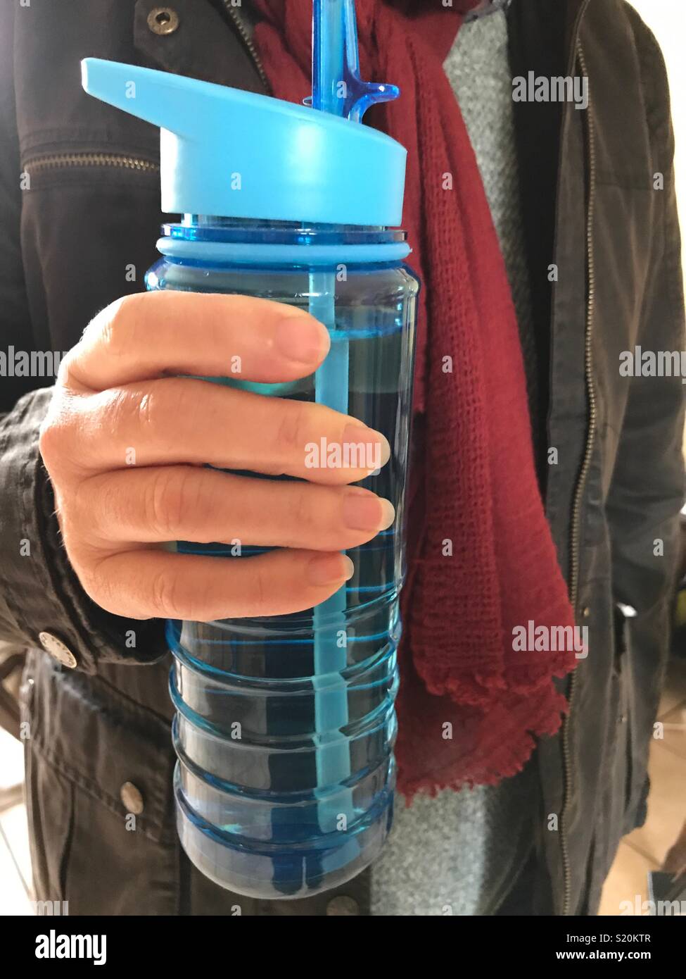 Frau mit einem wiederverwertbaren Kunststoff Flasche voll Wasser - Smartphone-aufgenommenes Stockfoto