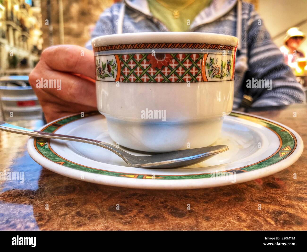 Frau genießt einen Kaffee in einem Straßencafé in der Altstadt von Javea / Xabia, Costa Blanca, Spanien - Smartphone-aufgenommenes Stockfoto