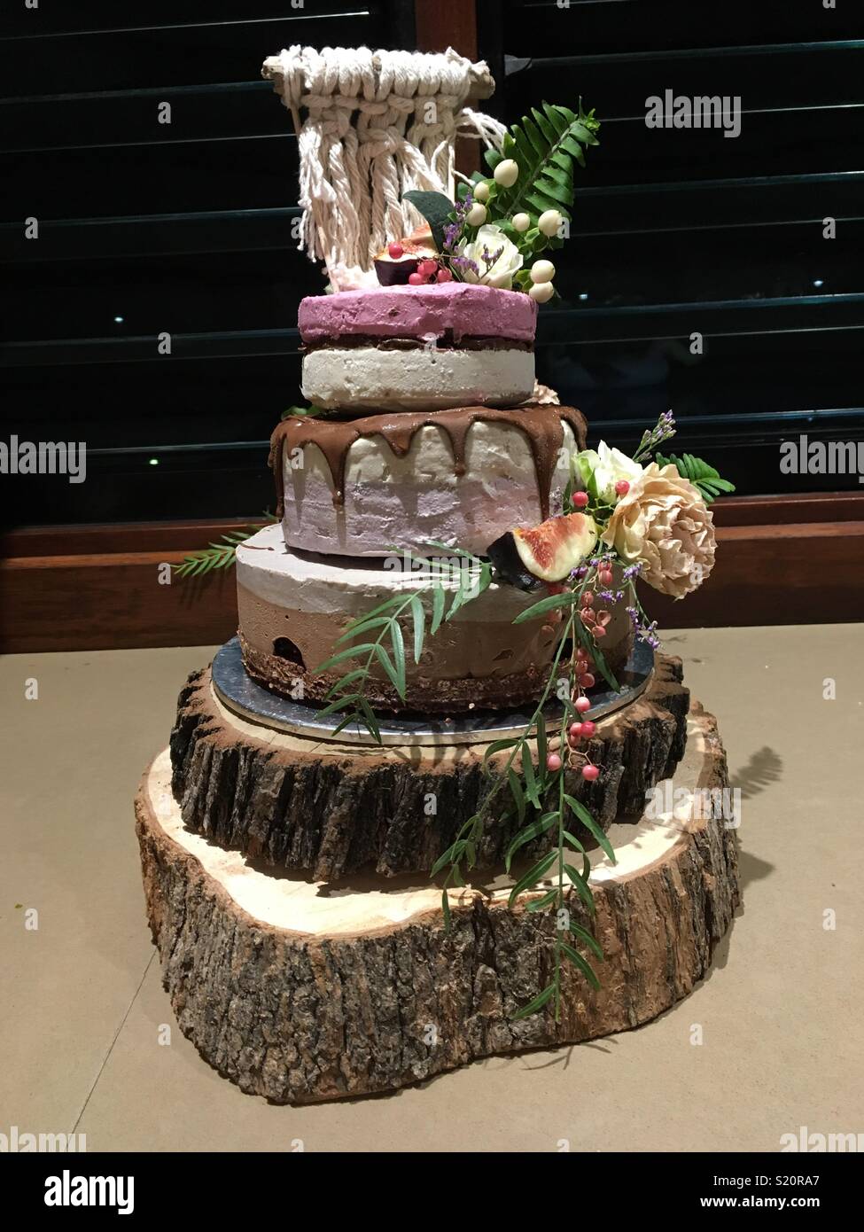 Raw vegan Hochzeitstorte mit Blumen und Obst Stockfoto