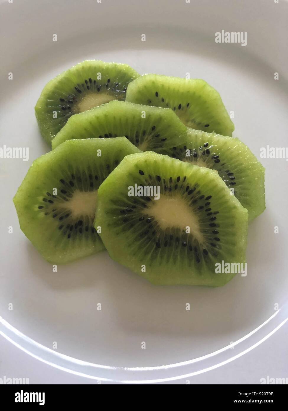 Kiwi-Scheiben auf weißen Teller Stockfoto