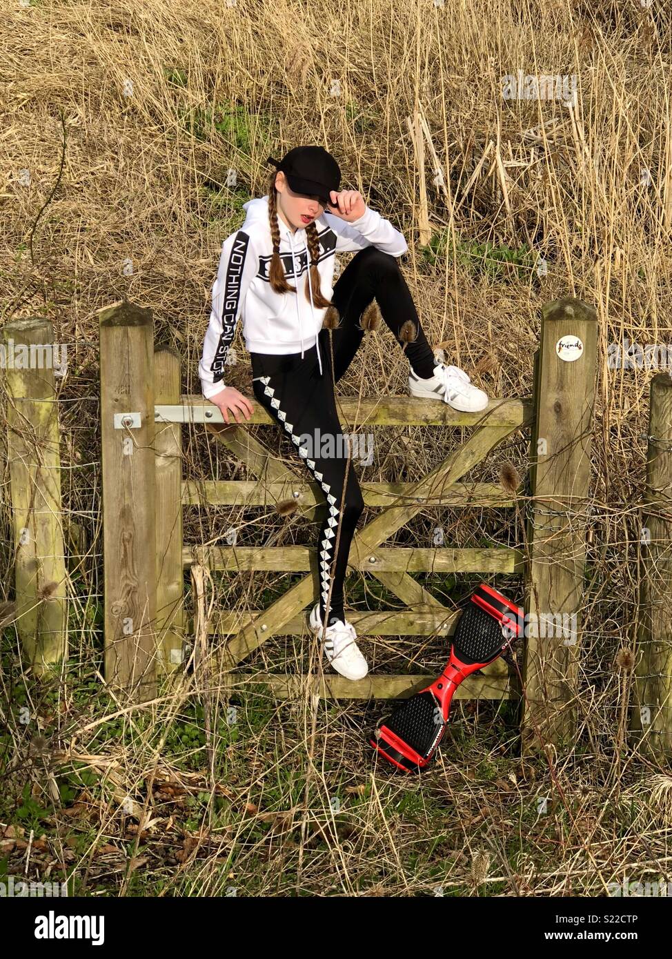 Mädchen mit Hoverboard auf ein Tor in einem Feld tragen coole Klamotten  Stockfotografie - Alamy