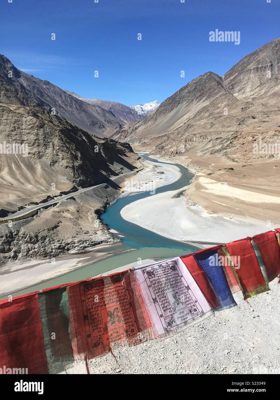Gebetsfahnen über Sangam, die Sitzung des Indus und Zanskar Flüsse in Ladakh, Indien Stockfoto