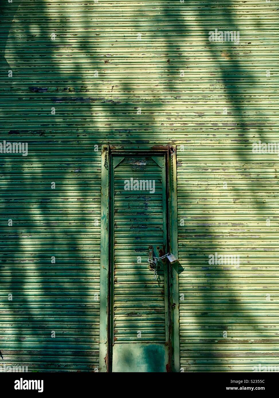 Verfallenes Haus mit Fensterläden aus Metall und mit einem Vorhängeschloss Tür, London Stockfoto