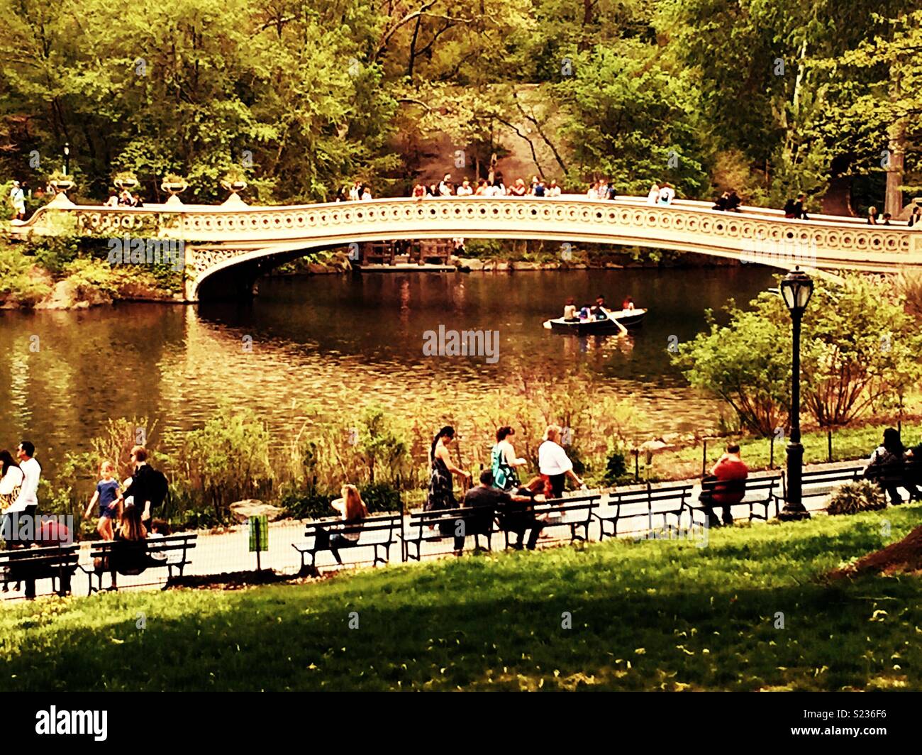 Touristen in Scharen in das blühende Bäume um Bogen Brücke am See im Central Park im Frühling, NYC, USA - Smartphone-aufgenommenes Stockfoto