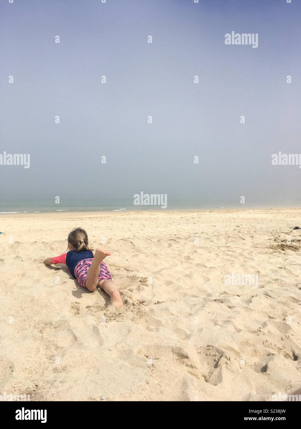 Porthminster Beach, St Ives, Cornwall, UK. 6. Mai 2018. UK Wetter. Kleines Mädchen mit auf goldenen Gelb Sand in der Nähe von Ocean vom Meer aus Nebel auf beliebten Reiseziel May Bank Holiday Wochenende umgeben. Stockfoto