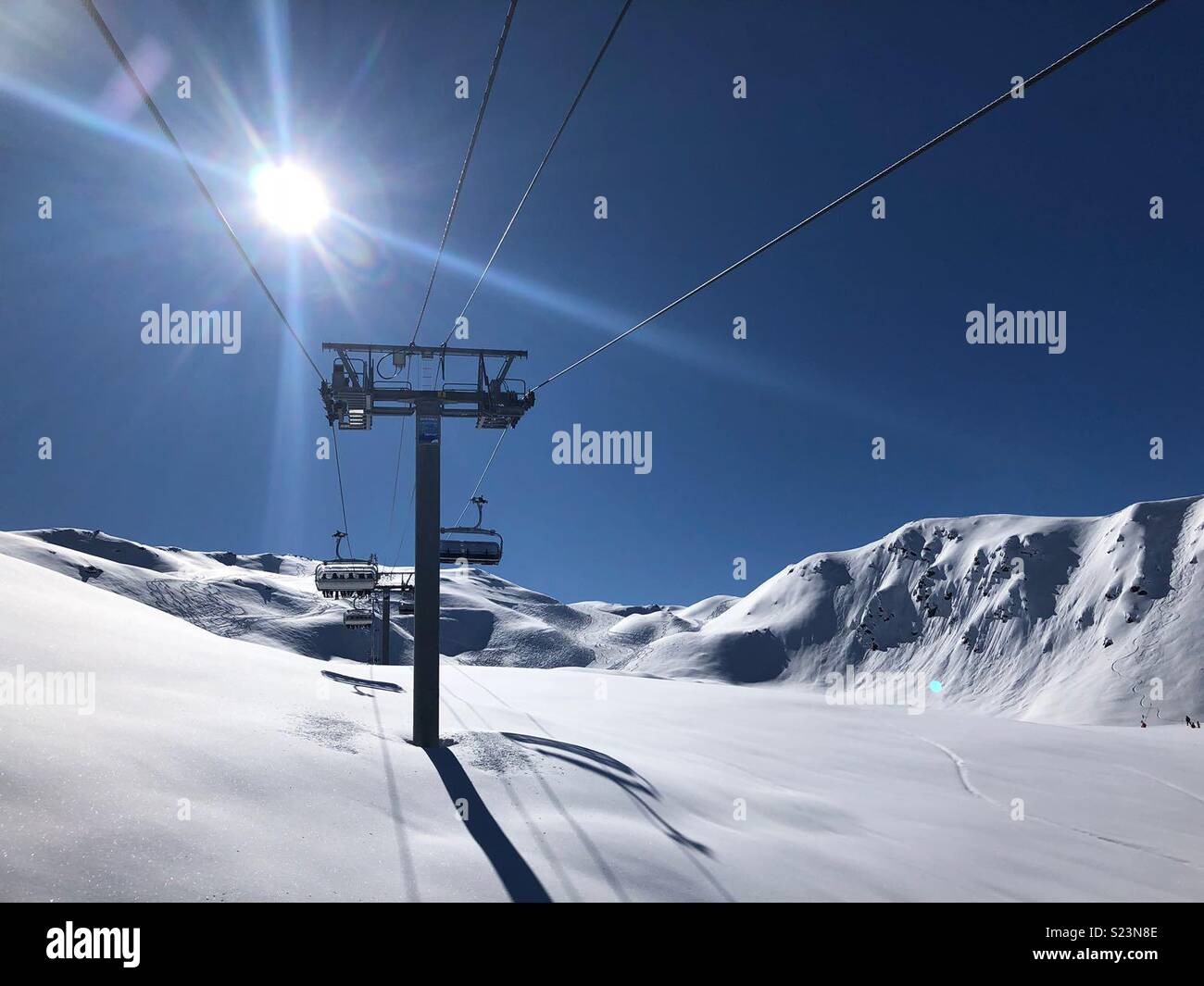 Auf der Sesselbahn in den 3 Vallées Skigebiet in strahlendem Sonnenschein Stockfoto