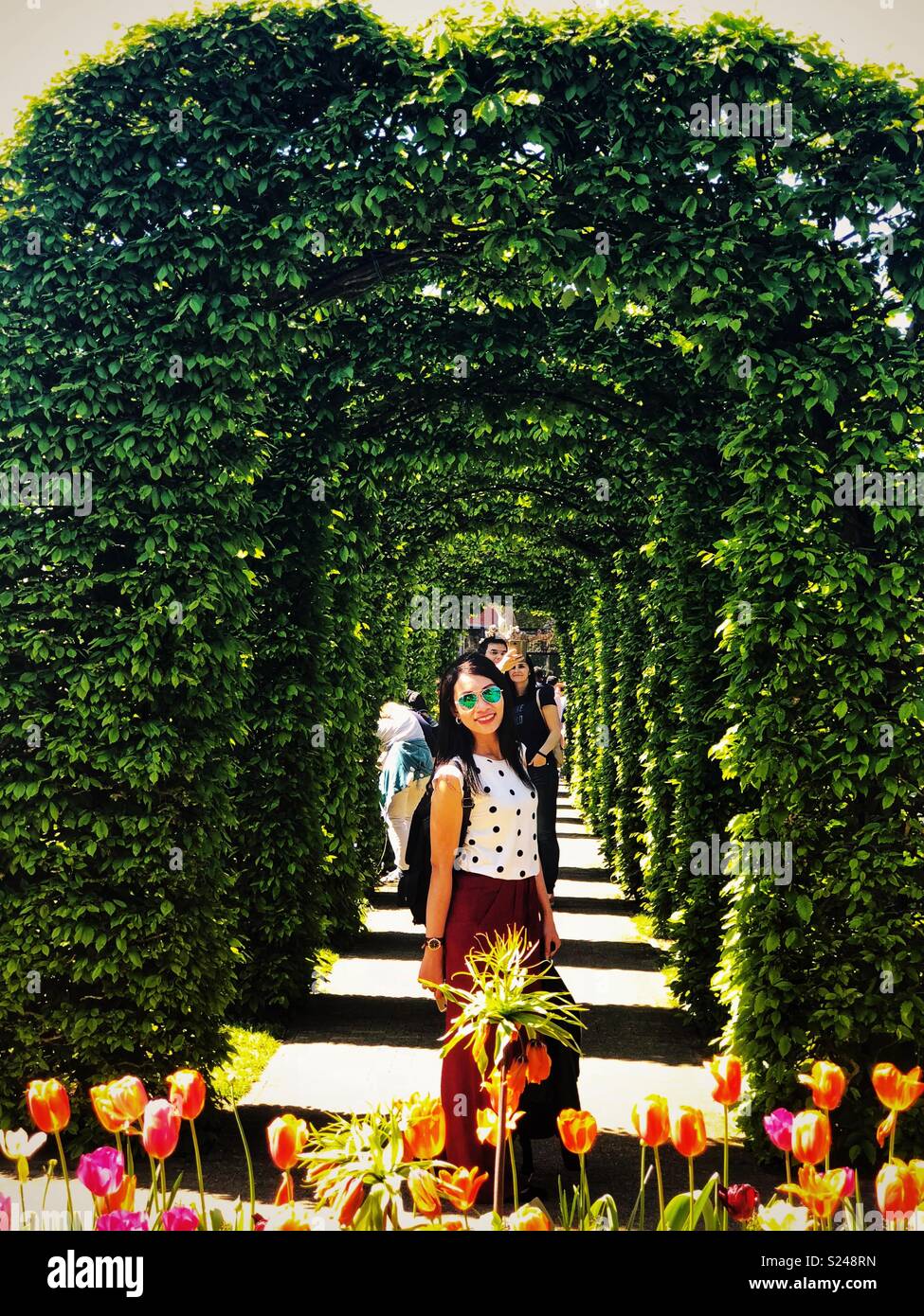 Bildnis einer Dame in einem formalen Garten. - Smartphone-aufgenommenes Stockfoto