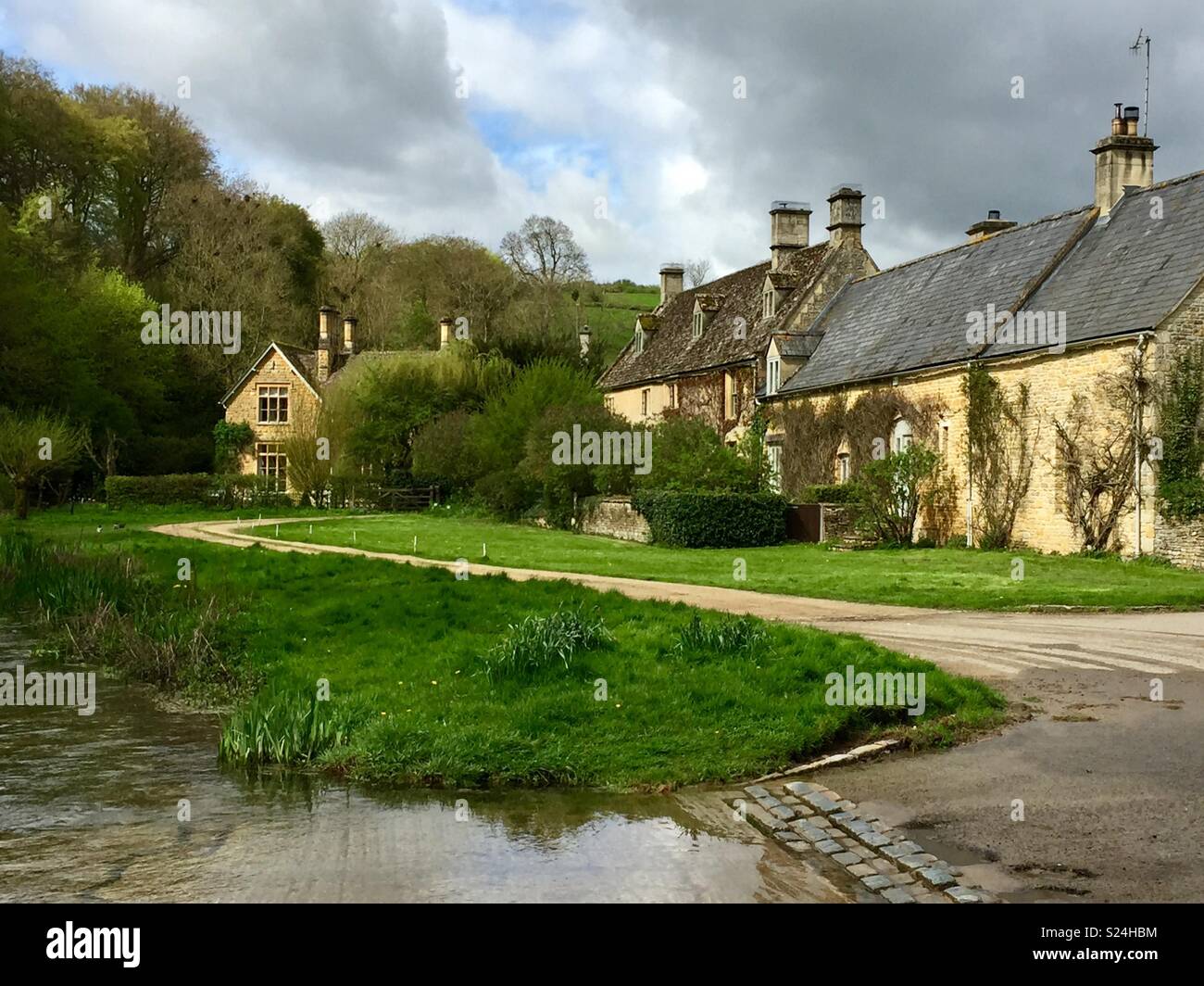 Eine Furt durch den Fluss Auge, das verbindet beide Seiten der Cotswolds Dorf Upper Slaughter. Mit Hütten und Kletterer im Hintergrund. Gloucestershire, Vereinigtes Königreich Stockfoto