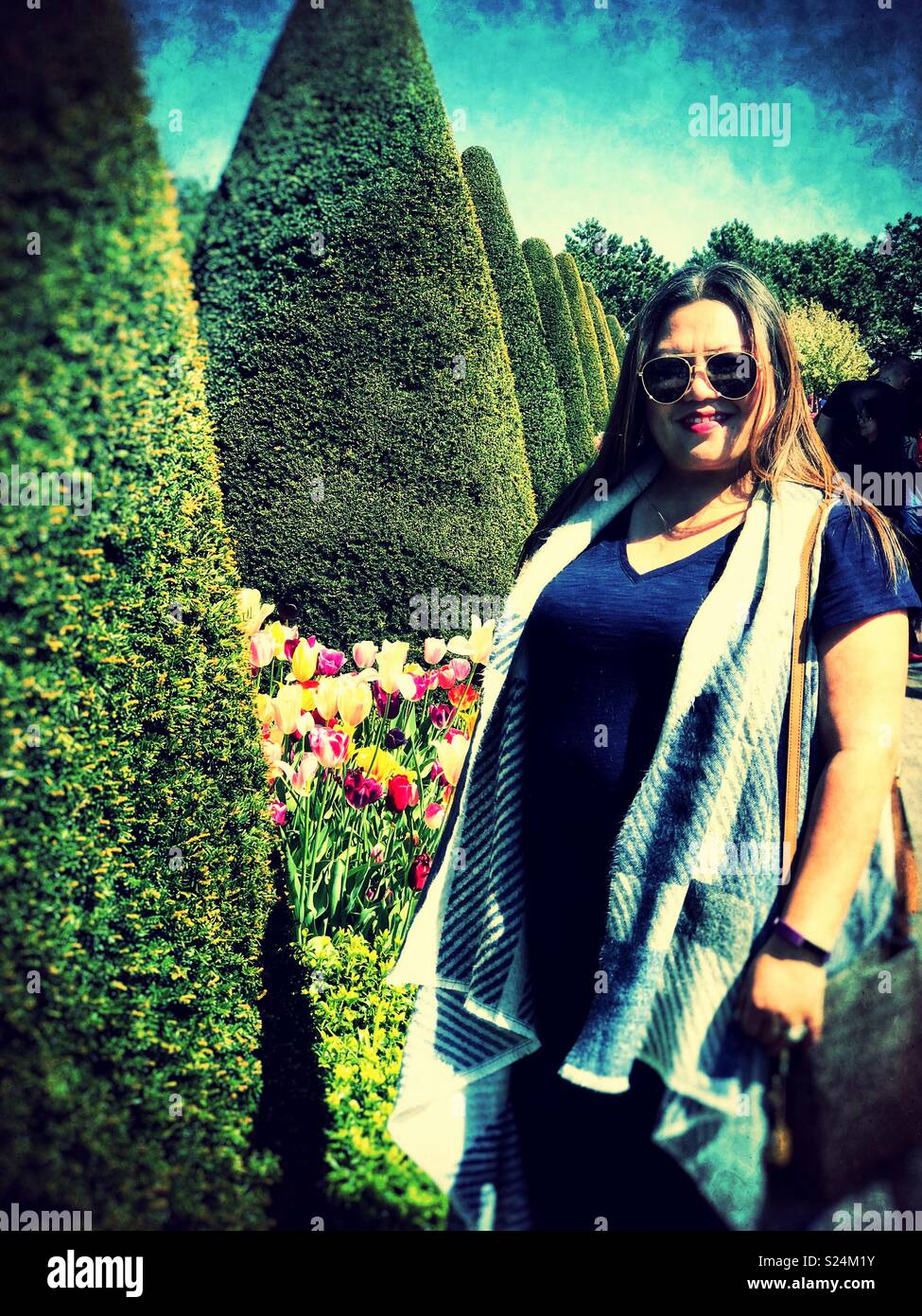 Das Porträt einer Dame in formalen Gärten. - Smartphone-aufgenommenes Stockfoto