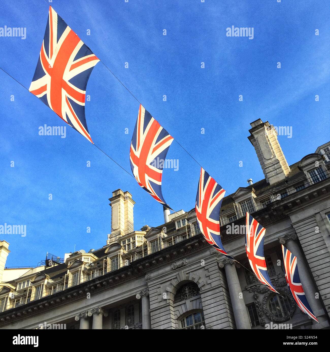 Zeichenkette mit Union Jack Fahnen über Regents Street, London, UK hängen. Stockfoto