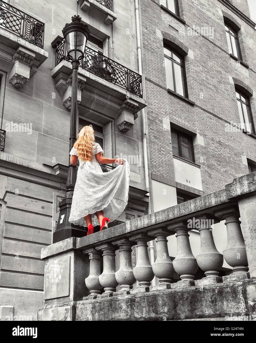 Blonde Modell in weissem Kleid und rote Schuhe in einem Pariser backstreet Posing Stockfoto