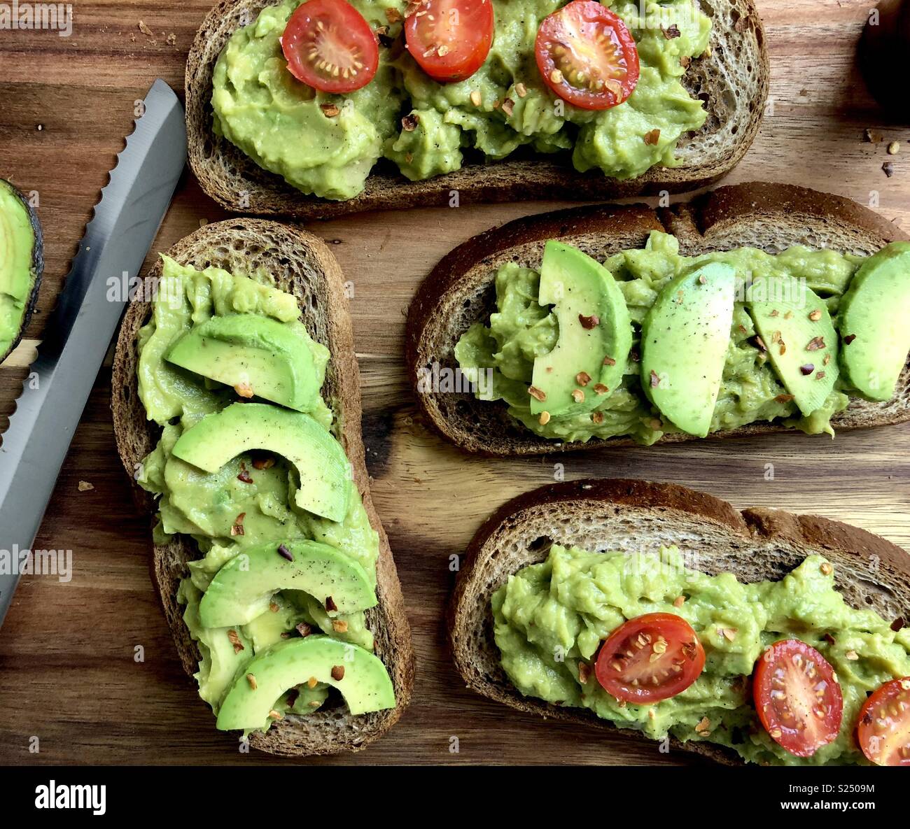 Blick von oben auf die Avocado Toast auf einem Holz Schneidebrett - Smartphone-aufgenommenes Stockfoto