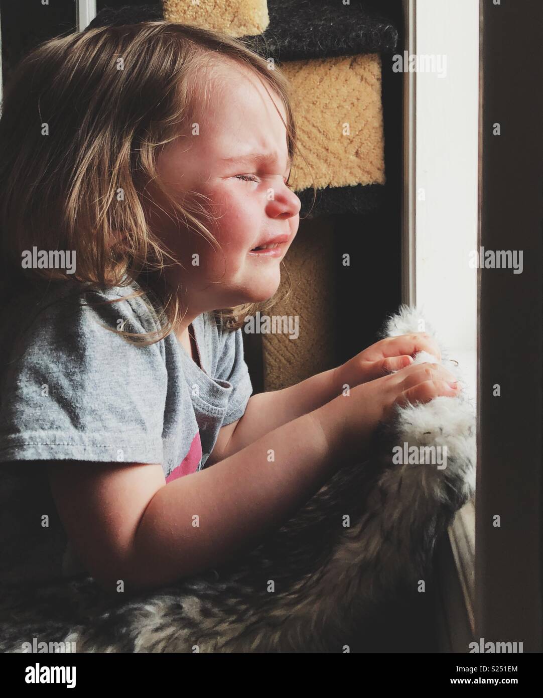 Kleinkind Mädchen weinend am Fenster während eines Temper Tantrum Stockfoto