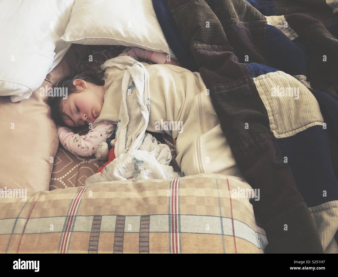 Kleinkind Mädchen schlafen im Bett der Eltern von Kissen für Sicherheit umgeben - Smartphone-aufgenommenes Stockfoto