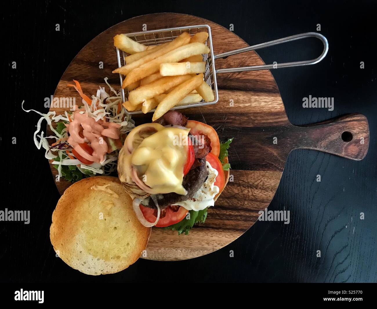 Großer Teil der Beef Burger und Pommes frites auf einer hölzernen Platte serviert. Stockfoto